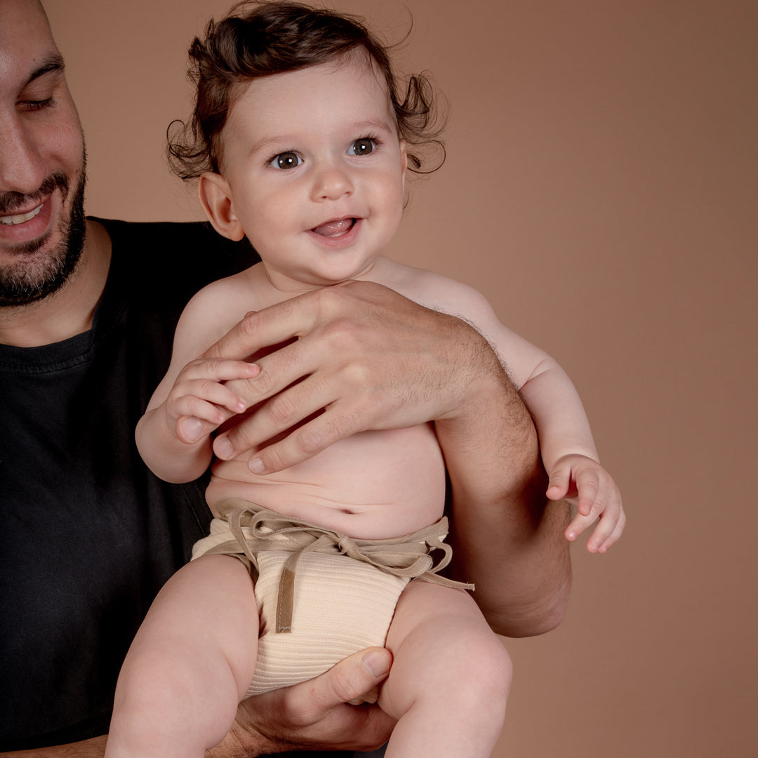 Baby trägt brauen Sumo Stoffwindel in Größe M