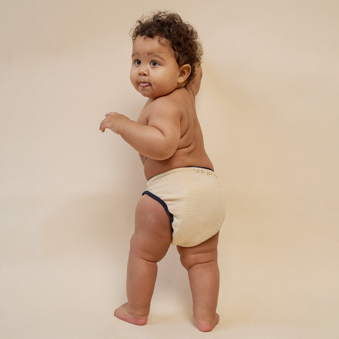 Baby trägt eine nachhaltige Stoffwindel von SUMO mit navy-blauem Bändchen